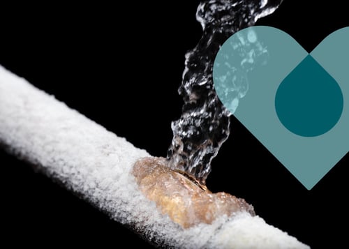 A frozen water pipe that has burst and spraying water